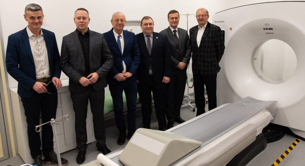 Sześciu mężczyzn stoi przy tomografie